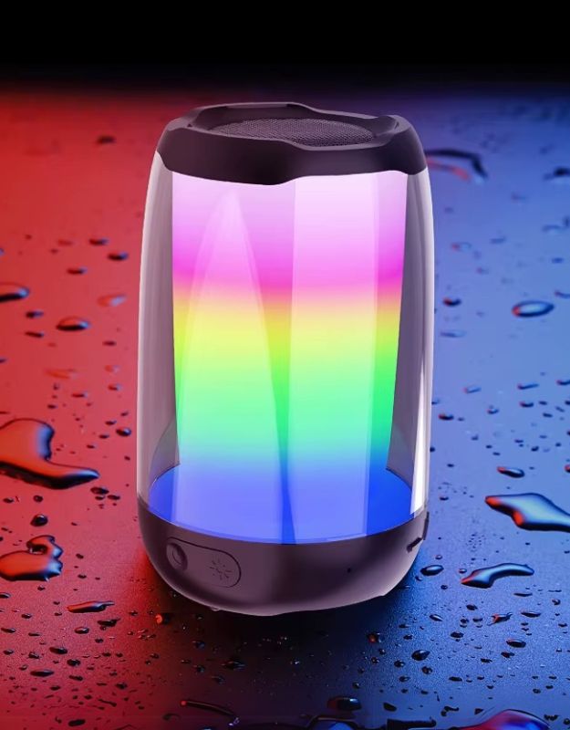 A portable wireless speaker with colorful LED lights, displayed against a backdrop with water droplets, suggesting its waterproof feature.