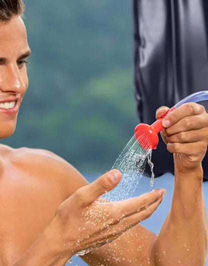 Man testing the red nozzle spray of the Bestway 58224 solar-heated multi-shower outdoors.