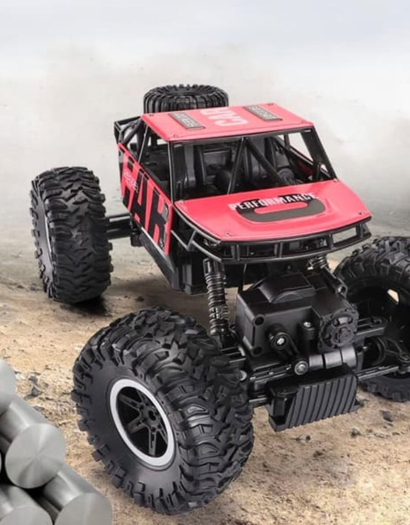 Red 4WD remote control monster truck driving on off-road terrain