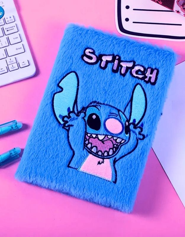 Blue notebook with a cartoon character on a pink surface