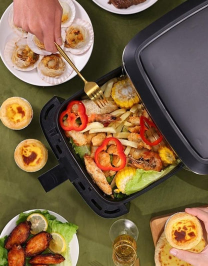 Air fryer basket filled with vegetables, chicken wings, and corn on the cob.