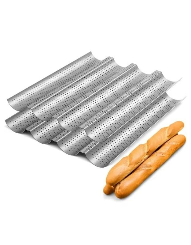 Set of perforated metal bread pans with two baguettes on a white background. Nonstick perforated baguette baking tray with two golden baguettes.