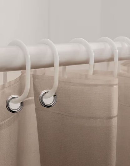 Closeup of beige striped shower curtain hanging on rod with hooks.