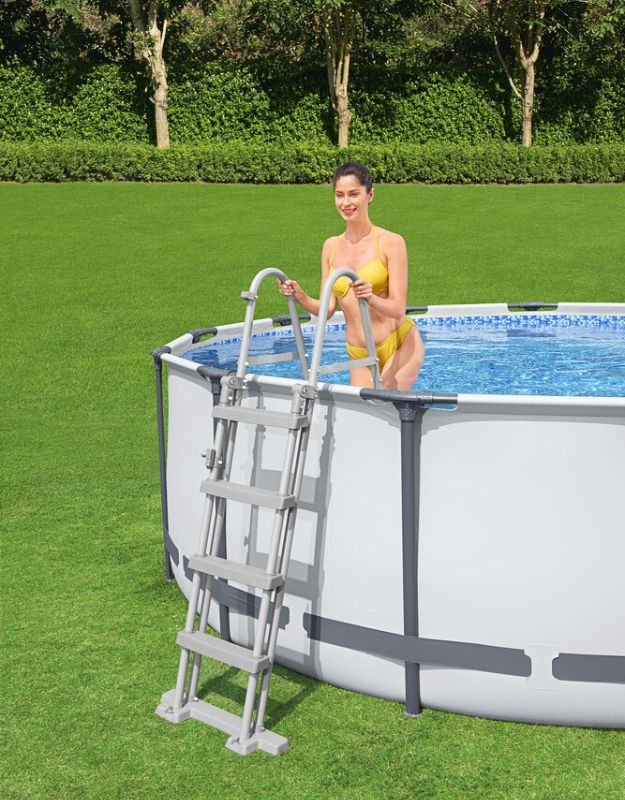 Woman using ladder to enter Bestway 5618W Steel Pro MAX round frame pool 396x122cm
