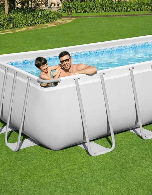 Father and son relaxing at the edge of the Bestway 564752 Power Steel rectangular above ground pool.