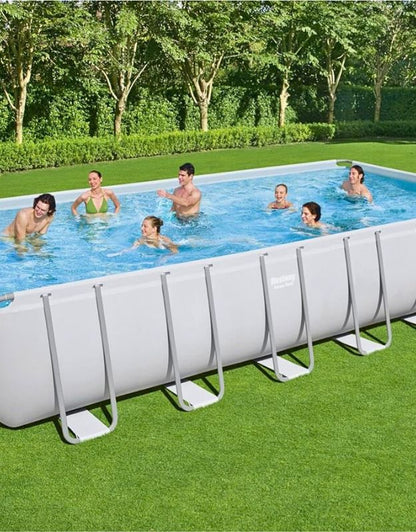 Group of people enjoying swimming in the Bestway 564752 Power Steel rectangular above ground pool in a garden.
