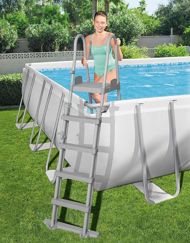 Woman climbing the ladder into the Bestway 564752 Power Steel rectangular above ground swimming pool
