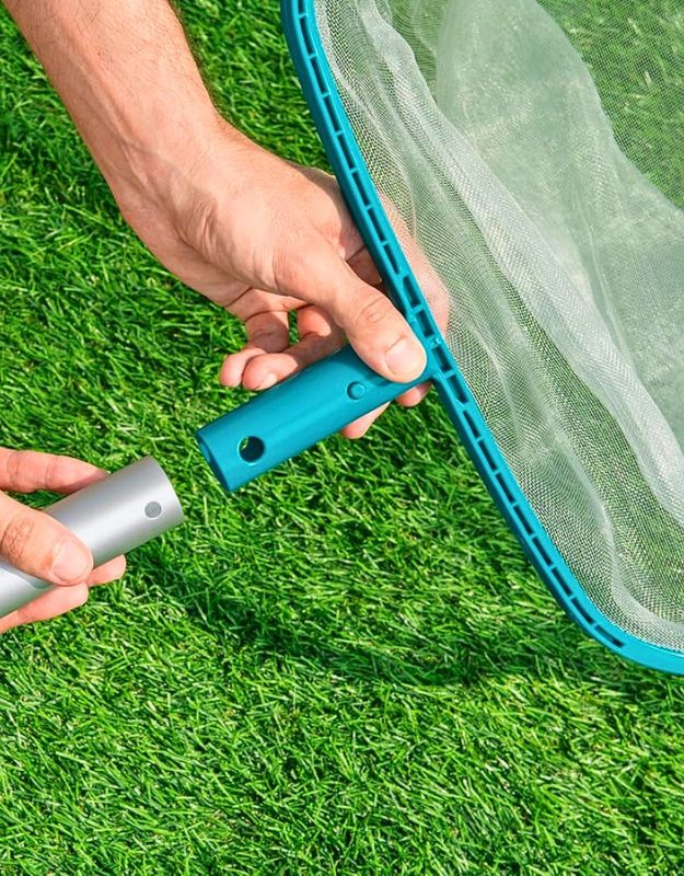 Hands assembling Bestway 58278 bottom landing net handle on green grass.