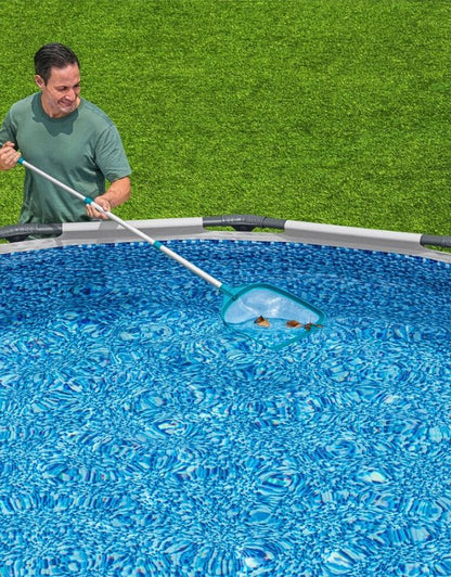Man using Bestway 58635 BW Pool Dust Net with telescopic handle to clean leaves from swimming pool.