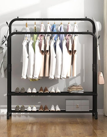 Black double clothing rack with two shelves for shoes and storage, holding clothes on hangers.