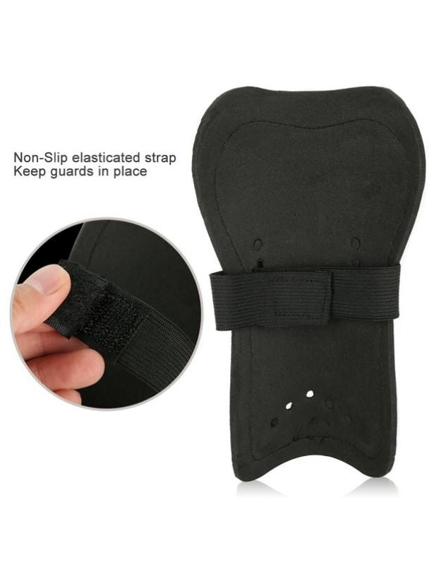 Black soccer shin guards with non-slip elastic strap design.