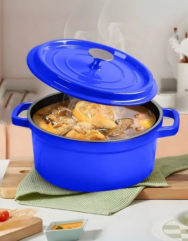 Blue pot with a lid on a kitchen counter, containing food. Blue enamel cast iron Dutch oven with lid slightly open, cooking hot stew.