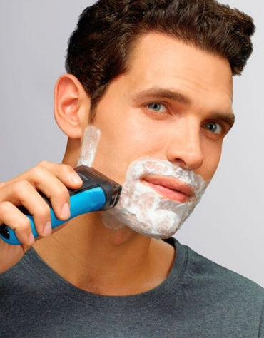 Man shaving with Braun 310s Series 3 wet and dry electric shaver using shaving foam