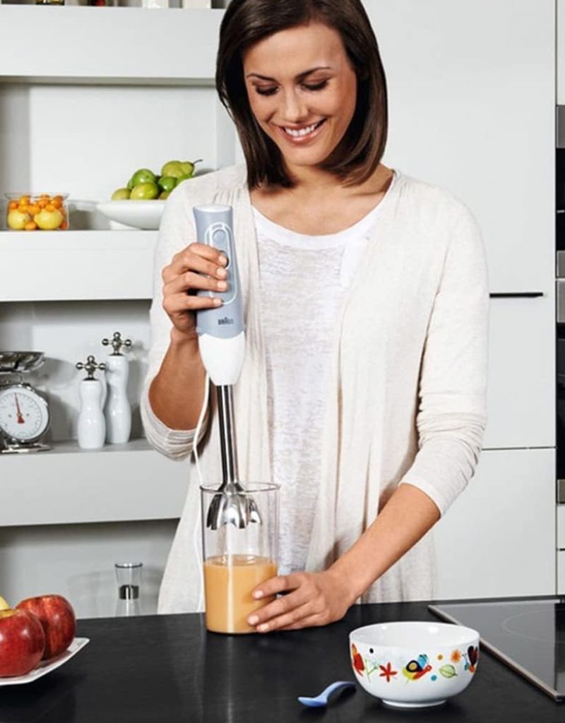 Woman using Braun MultiQuick 5 Hand Blender 600W to blend juice in kitchen