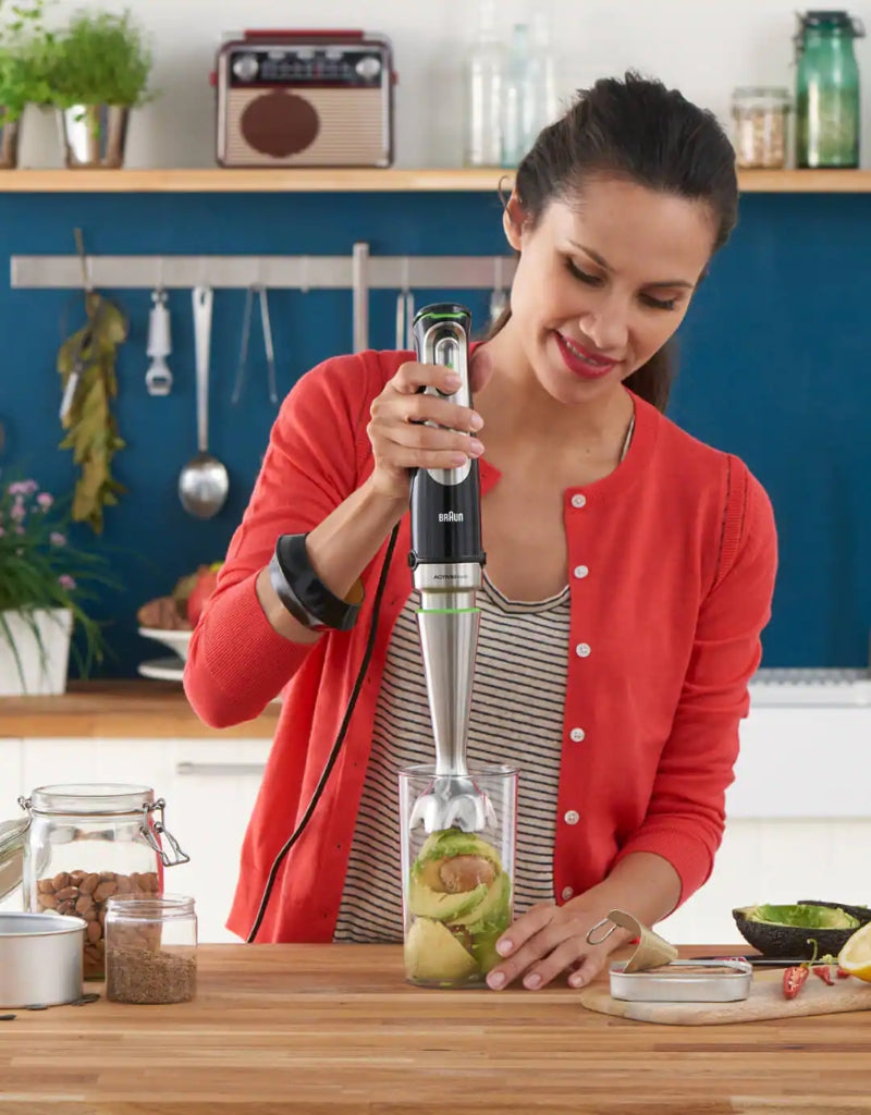 Woman using Braun Multiquick 9 Hand Blender to blend avocado in kitchen