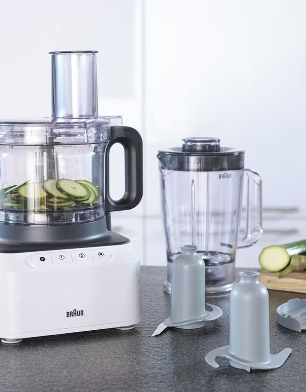 Braun PurEase food processor slicing cucumbers with attachments.