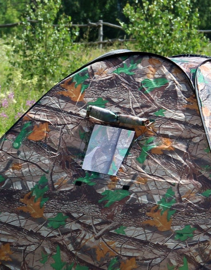 Close-up of camouflage camping tent with mesh side window.