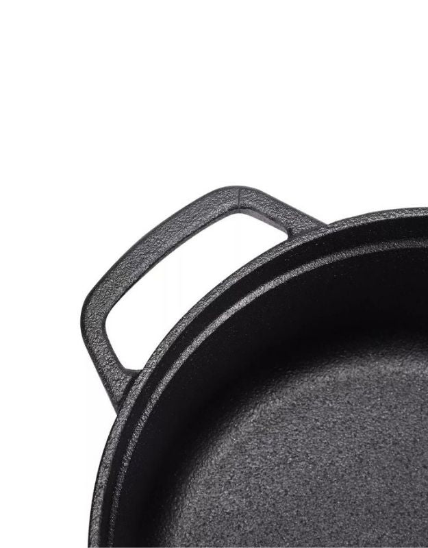 Close-up of a black cast iron skillet on a white background. Close-up of a durable handle on a black cast iron cooking pot.