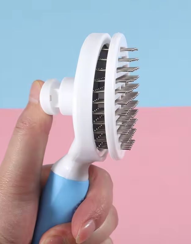 Side view of cat and dog grooming brush with stainless steel bristles.