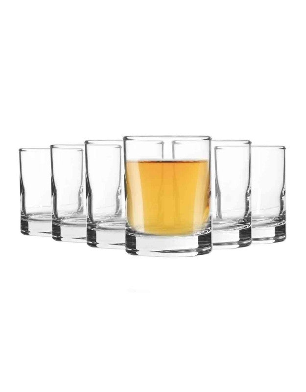 Set of clear glasses with one containing a yellow liquid on a white background.