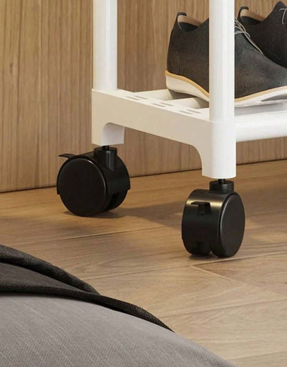 Close-up of a white chair with black wheels on a wooden floor. Clothing rack with strong rolling wheels close-up view.