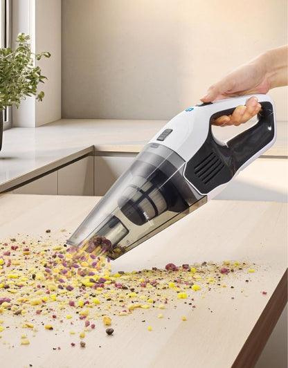 Cordless handheld vacuum cleaner removing food crumbs on kitchen counter.