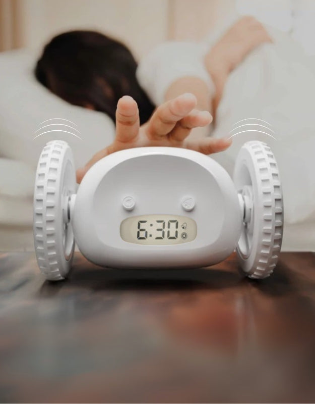 White clocky alarm clock on bedside table with loud digital alarm ringing