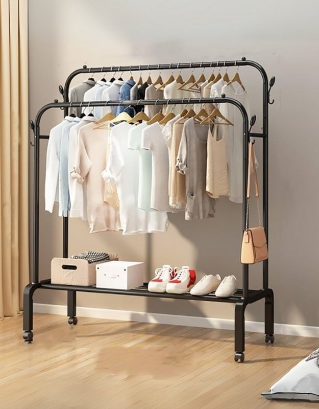 A black double pole cloth hanger and organizer rack with wheels, displayed with clothes and storage boxes on it.
