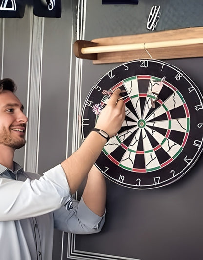 Adult man removing darts from a dart board while playing indoors