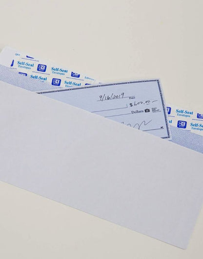 White self-seal envelope with a check partially inserted, showing a dated check with "$600.00" written on it.
