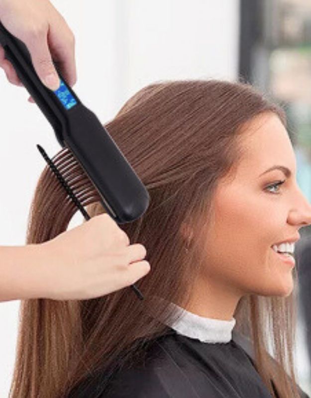 Hair stylist using Enzo EN-3867 adjustable temperature hair straightener on woman’s long hair.