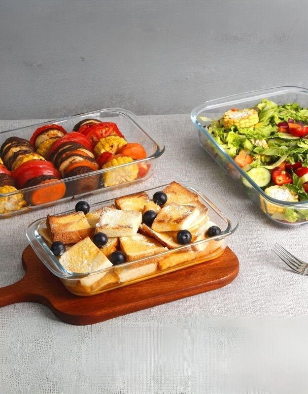 Fenix glass bakeware set with dessert, salad, and roasted vegetables on table