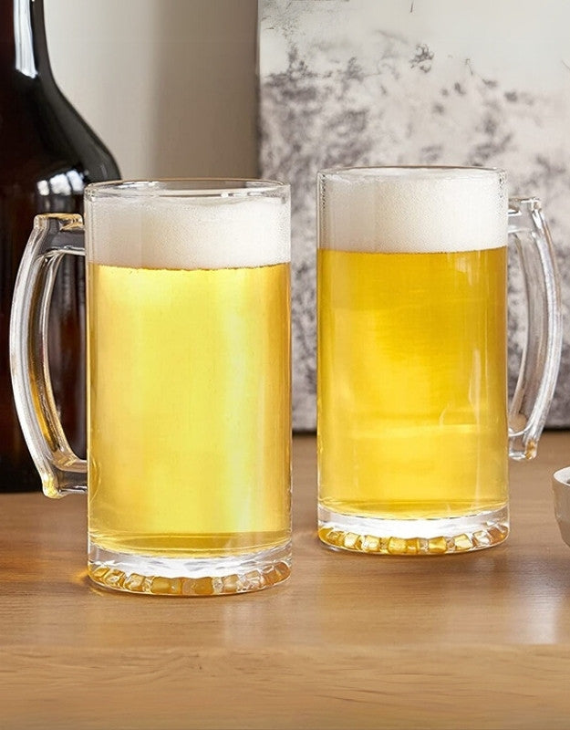 Two glasses of beer on a wooden table with a blurred background.  
Two glass beer mugs filled with golden beer and foam on a wooden table.