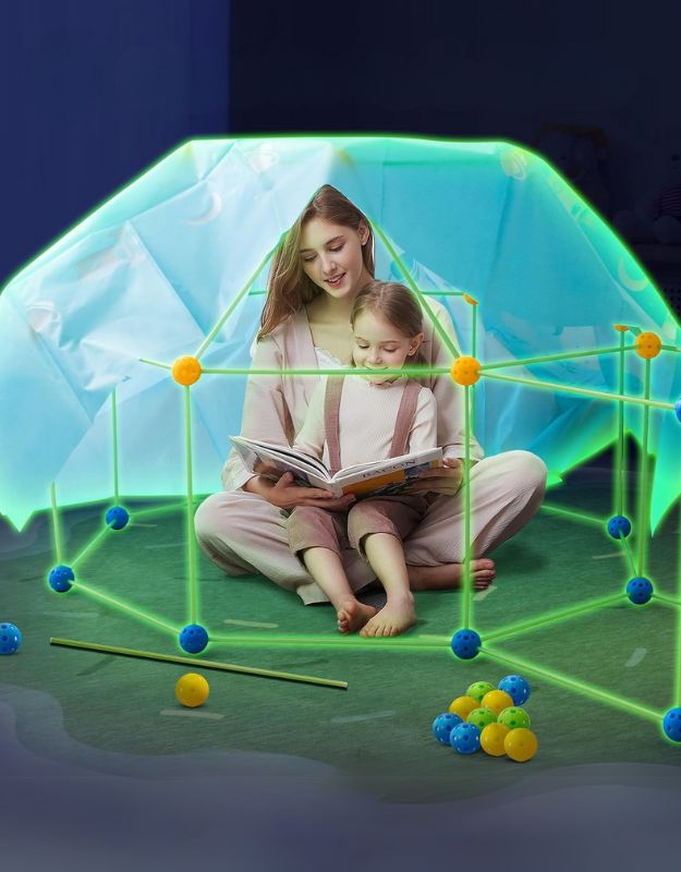 Mom and child reading a book inside a glow-in-the-dark fort built with Magic Fort kit.