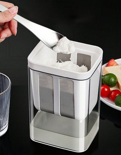 Hand scooping thick strained Greek yogurt from strainer container.