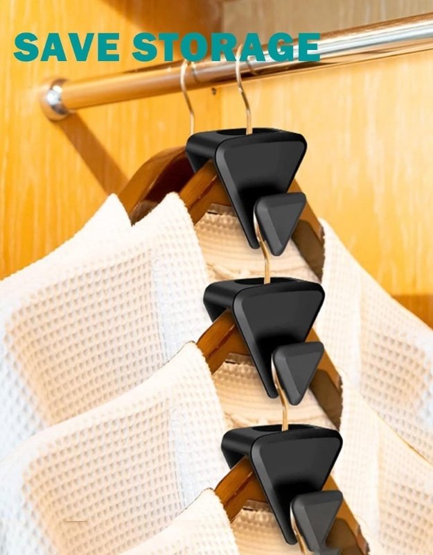 Hanger with black triangular hooks holding up clothes against a wooden background.
