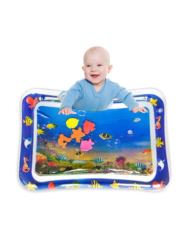 A joyful baby in a blue long-sleeved onesie smiling while positioned on their tummy over the inflatable water play mat