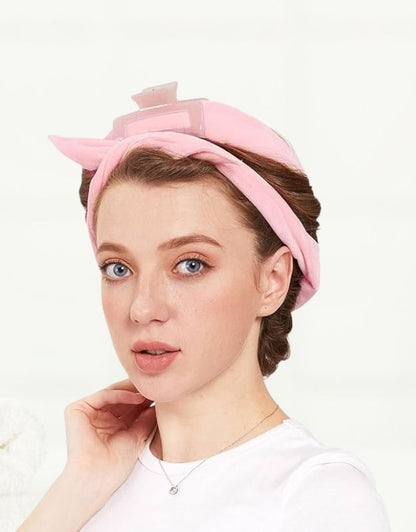 A woman wearing a pink velour hair curling headband.