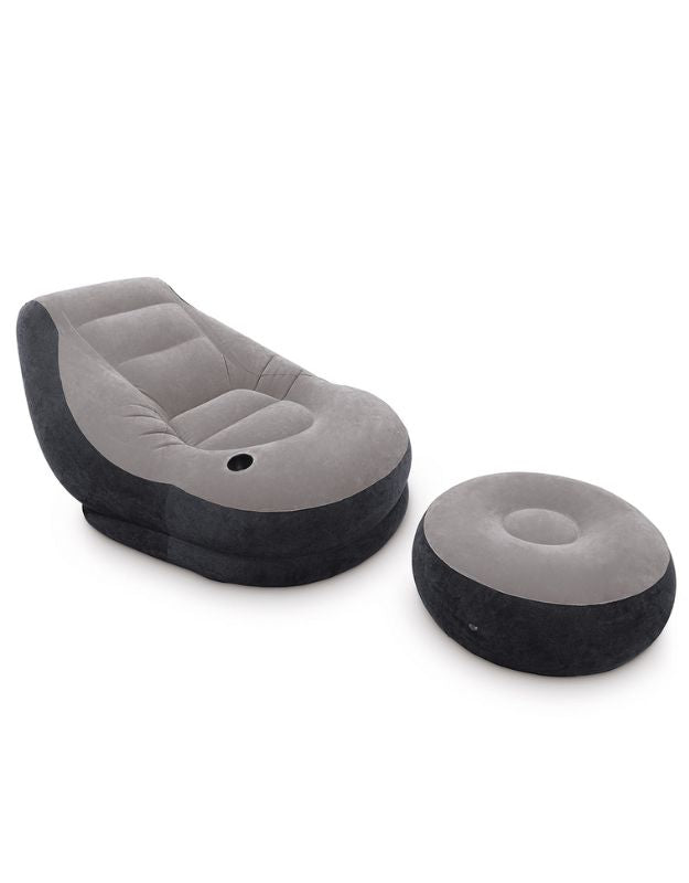 Grey inflatable lounge chair with matching round ottoman, modern portable seating.