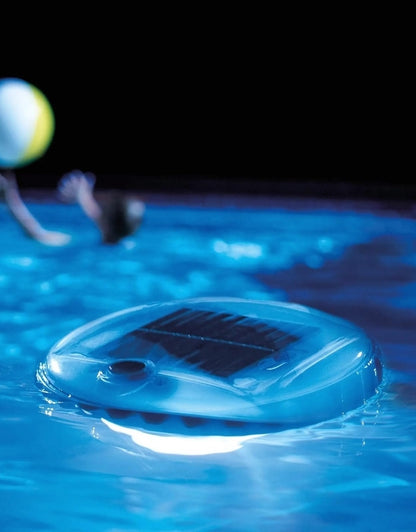 Intex 28695 solar powered floating lantern illuminating swimming pool at night.