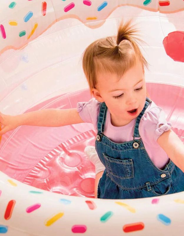 Toddler playing inside Intex 48476 My First Gym inflatable baby play gym with sprinkle design.