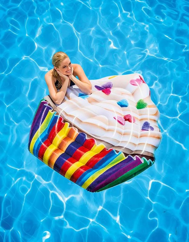 Woman relaxing on Intex 58770EU inflatable cupcake pool float with rainbow base and colorful heart toppings