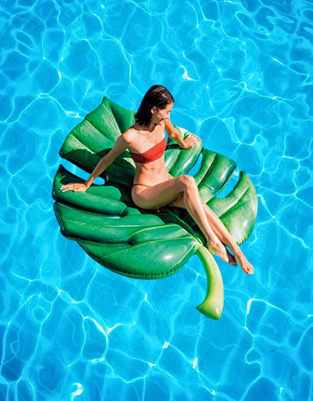 Woman relaxing on Intex 58782EU Palm Leaf Inflatable Pool Mat in swimming pool
