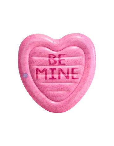 A pink heart-shaped inflatable pool float with the words "BE MINE" printed in bold letters at the center.