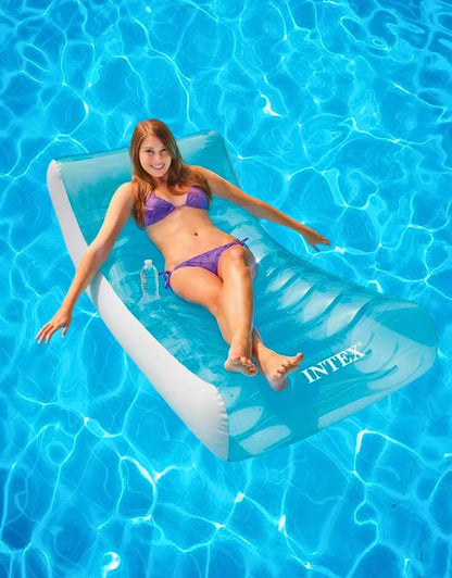 Woman relaxing on Intex luxury ghost inflatable lounger pool float in turquoise color.