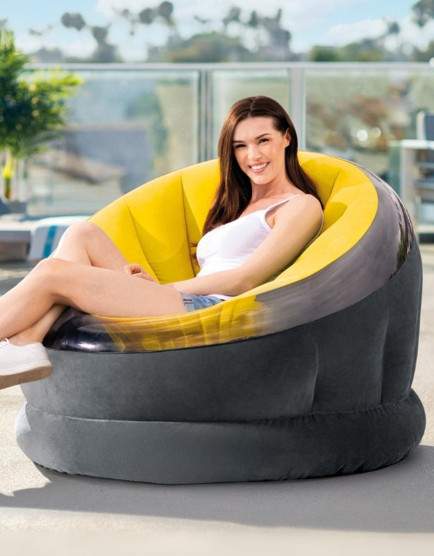 Woman relaxing outdoors on the Intex 66582NP Empire Yellow Inflatable Chair with yellow interior and black exterior