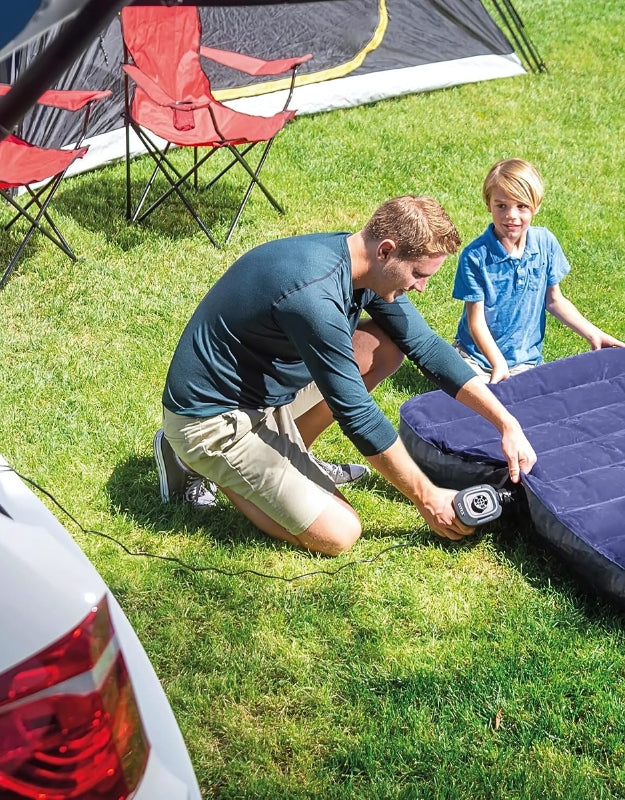 Man inflating air mattress outdoors using Intex 66634 portable electric air pump