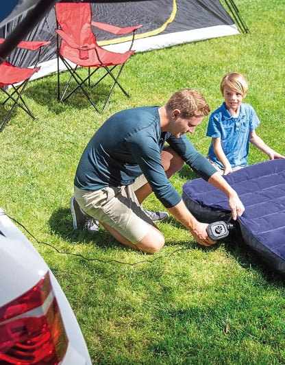 Man inflating air mattress outdoors using Intex 66634 portable electric air pump