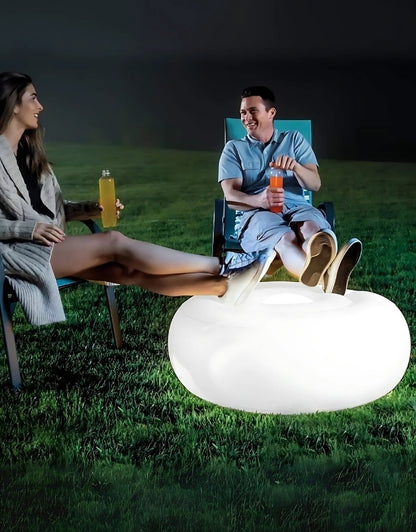 Intex 68697 inflatable pouf LED ottoman used outdoors as glowing seat at night.