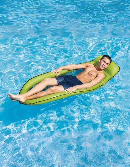 A person relaxing on the green inflatable net recliner in a pool
